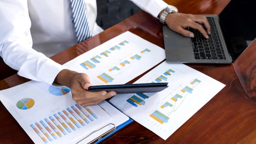 The businessman hand sits at their desks and calculates marketing graphs showing the results of their marketing strategy the process of successful business growth.
