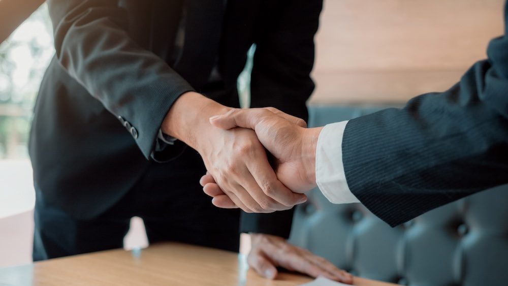 Department heads manager are shaking hands and accept to new employee in office room.